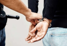 Person in handcuffs being arrested by police officer