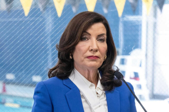 Woman in blue blazer speaking into microphone