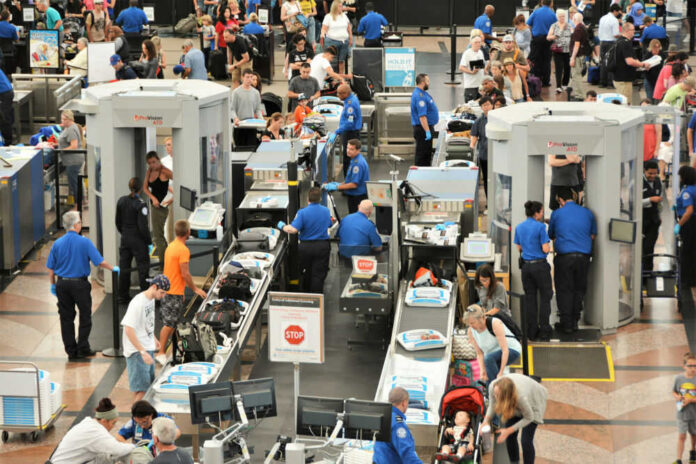 Airport security checkpoint with passengers and staff busy