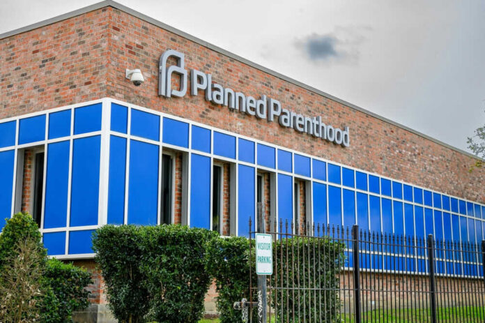 Brick building with blue windows and logo signage
