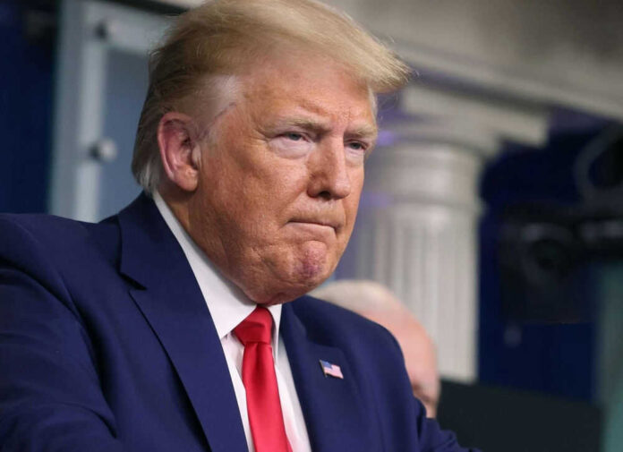 Man in suit and red tie looks serious