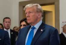 Man in blue suit with serious expression indoors