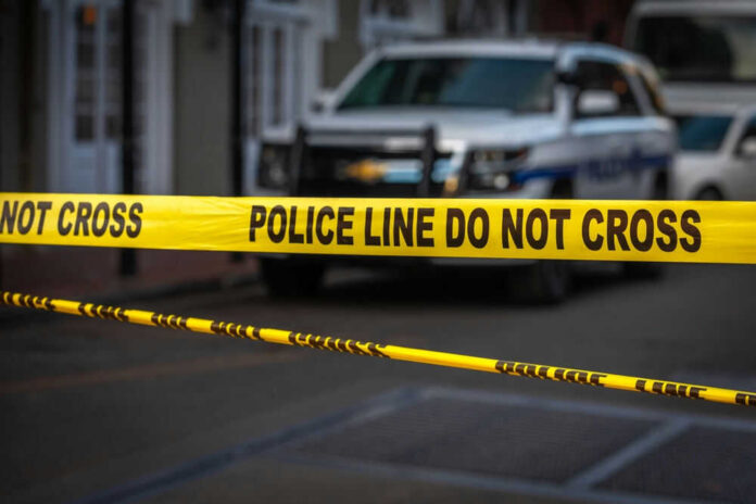 Yellow police tape in front of blurred vehicles