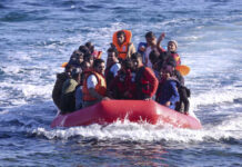 A group of people in a red inflatable boat on the ocean
