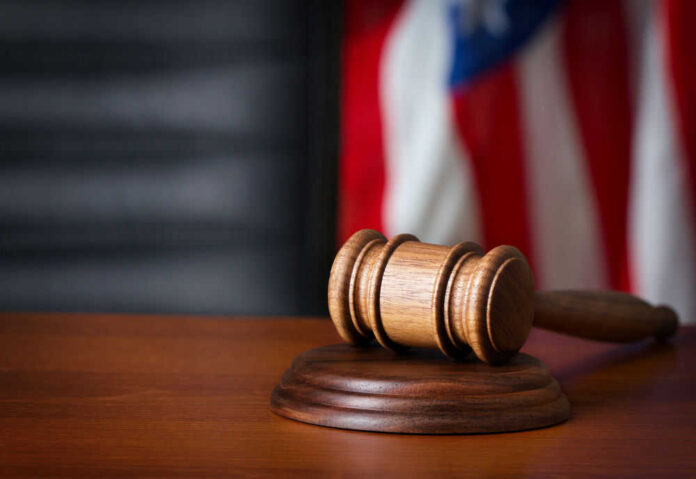 Gavel on wooden table with American flag background