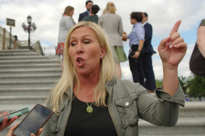 Woman gesturing and speaking outside on steps.